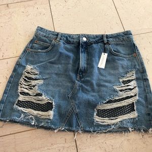 Distressed denim skirt with fishnet details